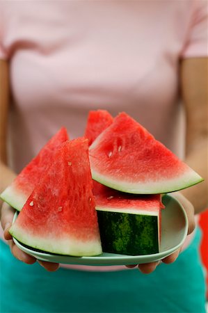 simsearch:659-01864546,k - Woman holding bowl of watermelon wedges Stock Photo - Premium Royalty-Free, Code: 659-01845329