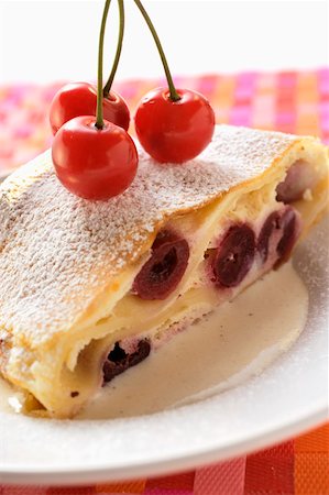 strudel - Piece of cherry strudel with icing sugar and fresh cherries Fotografie stock - Premium Royalty-Free, Codice: 659-01845369