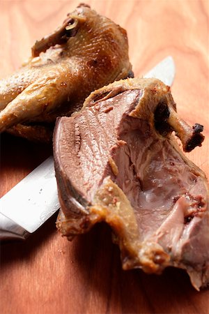 Roast pigeon, halved, on knife Foto de stock - Sin royalties Premium, Código: 659-01845436