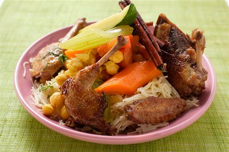 Roast pigeon with vegetables and cinnamon sticks on noodles Stock Photo - Premium Royalty-Free, Code: 659-01845439