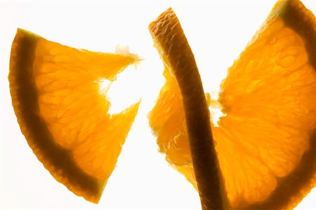 Slice of orange cut into two pieces, backlit Stock Photo - Premium Royalty-Free, Code: 659-01845603