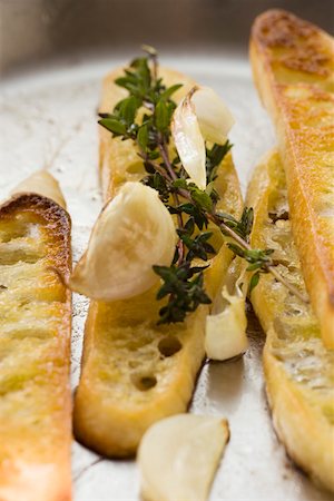 pane all'aglio - Slices of toasted white bread with garlic and thyme Fotografie stock - Premium Royalty-Free, Codice: 659-01845699