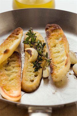 simsearch:659-01845699,k - Slices of toasted white bread with garlic and thyme Foto de stock - Royalty Free Premium, Número: 659-01845700