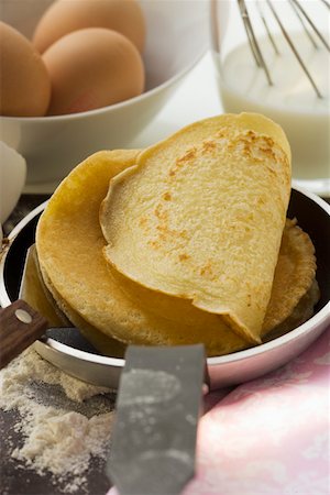 Piling up pancakes in frying pan Stock Photo - Premium Royalty-Free, Code: 659-01845728