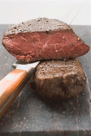 pan fried fillet of beef - Beef steaks, one with a piece cut off, with knife Stock Photo - Premium Royalty-Free, Code: 659-01845774