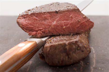 pan fried fillet of beef - Beef steaks, one with a piece cut off, with knife Stock Photo - Premium Royalty-Free, Code: 659-01845775