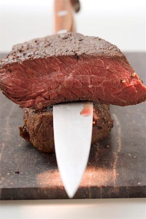 Beef steaks, one with a piece cut off, with knife Stock Photo - Premium Royalty-Free, Code: 659-01845776