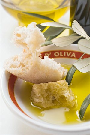 Huile d'olive dans un bol avec le pain blanc, rameau d'Olivier, carafe Photographie de stock - Premium Libres de Droits, Code: 659-01845834