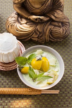 simsearch:659-01847309,k - Coconut soup with fish and Thai aubergines in front of Buddha Foto de stock - Sin royalties Premium, Código: 659-01845958