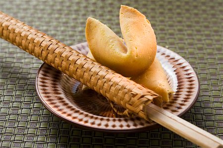 Fortune cookies and chopsticks in woven wrapper on plate Foto de stock - Royalty Free Premium, Número: 659-01845964