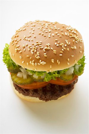 simsearch:659-01846088,k - Hamburger with tomato, gherkin, onions and lettuce Foto de stock - Sin royalties Premium, Código: 659-01846052