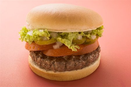 simsearch:659-01846088,k - Hamburger with tomato, gherkin, onion and lettuce Foto de stock - Sin royalties Premium, Código: 659-01846053