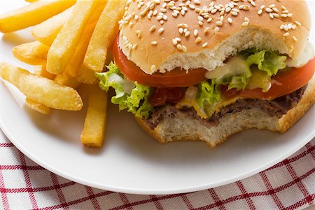 simsearch:659-01846088,k - Cheeseburger, bites taken, with chips Foto de stock - Sin royalties Premium, Código: 659-01846074