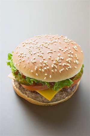 simsearch:659-01846088,k - Cheeseburger with tomatoes, lettuce and ketchup Foto de stock - Sin royalties Premium, Código: 659-01846088