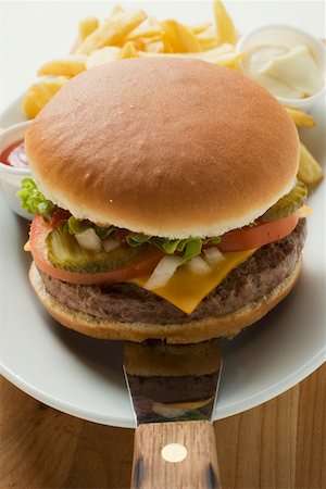 simsearch:659-01847504,k - Cheeseburger with accompaniments on plate Stock Photo - Premium Royalty-Free, Code: 659-01846110