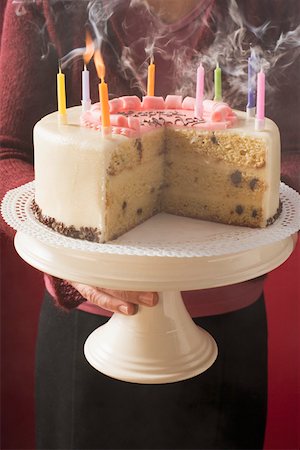 simsearch:659-01846253,k - Woman serving birthday cake with blown-out candles Stock Photo - Premium Royalty-Free, Code: 659-01846265