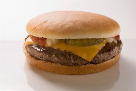 Cheeseburger with gherkin, onions and ketchup Stock Photo - Premium Royalty-Free, Code: 659-01846315