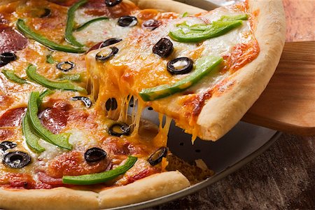 simsearch:659-01853076,k - Pizza with cheese, salami, peppers and olives, a piece cut Fotografie stock - Premium Royalty-Free, Codice: 659-01846487