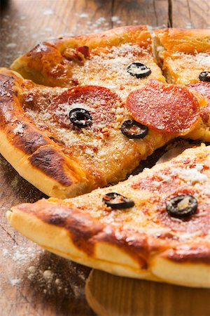 simsearch:659-01847562,k - Pizza with salami, cheese and olives, pieces cut Stock Photo - Premium Royalty-Free, Code: 659-01846480