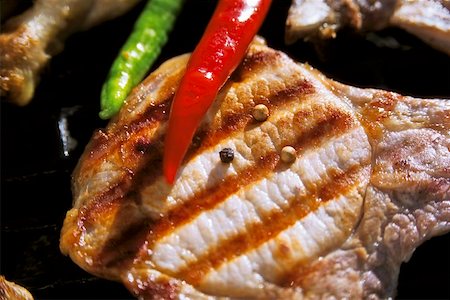 Grilled pork chop with pepper and chili peppers Fotografie stock - Premium Royalty-Free, Codice: 659-01846553