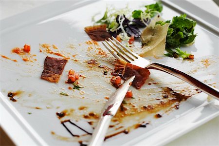 empty plate of food - Scraps of food on a plate with cutlery Stock Photo - Premium Royalty-Free, Code: 659-01846621