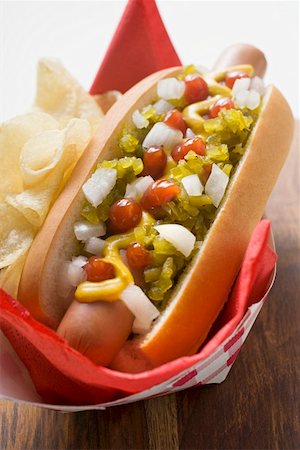 Hot dog with relish, mustard, ketchup, onions and crisps Stock Photo - Premium Royalty-Free, Code: 659-01847329