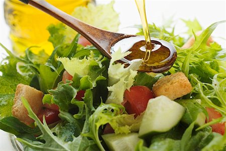 simsearch:659-01847395,k - Pouring olive oil into wooden spoon above salad leaves Foto de stock - Sin royalties Premium, Código: 659-01847406