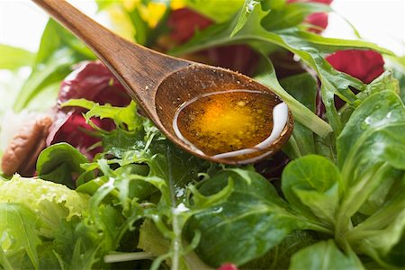 Olive oil in wooden spoon above salad leaves Stock Photo - Premium Royalty-Free, Code: 659-01847401