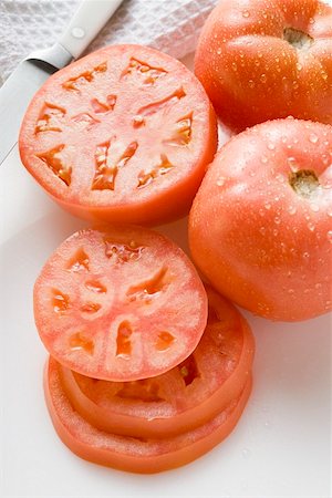 Tomatoes, whole, halved and slices, with drops of water Stock Photo - Premium Royalty-Free, Code: 659-01847422