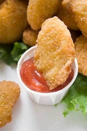 simsearch:659-01847449,k - Dipping Chicken Nugget into ketchup Stock Photo - Premium Royalty-Free, Code: 659-01847444