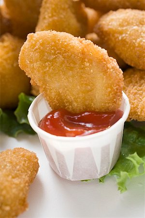 simsearch:659-01847943,k - Dipping Chicken Nugget into ketchup Stock Photo - Premium Royalty-Free, Code: 659-01847443