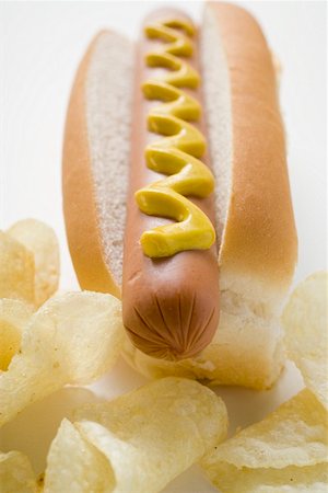 Hot dog with mustard and potato crisps Stock Photo - Premium Royalty-Free, Code: 659-01847479