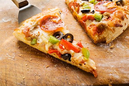 simsearch:659-01866072,k - Piece of pepperoni pizza with peppers and olives on server Foto de stock - Sin royalties Premium, Código: 659-01847564