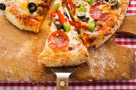 simsearch:659-01866072,k - Pepperoni pizza with peppers and olives on wooden plate Foto de stock - Sin royalties Premium, Código: 659-01847563