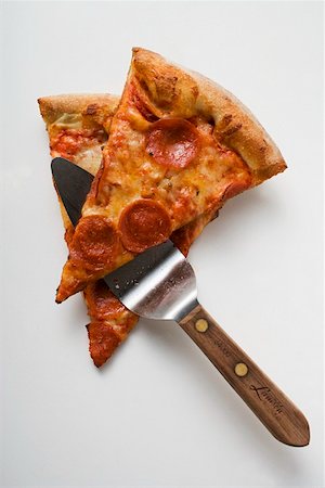 simsearch:659-01860315,k - Two pieces of pepperoni pizza with server Stock Photo - Premium Royalty-Free, Code: 659-01847613