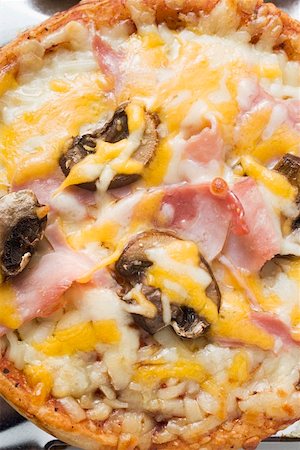 Mini-pizza with ham, mushrooms and cheese Stock Photo - Premium Royalty-Free, Code: 659-01847669