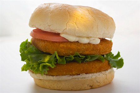 simsearch:659-01847813,k - Double chicken burger with tomato mayonnaise and lettuce Foto de stock - Sin royalties Premium, Código: 659-01847805