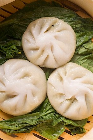 Three filled yeast dumplings on pak choi (Thailand) Stock Photo - Premium Royalty-Free, Code: 659-01847837