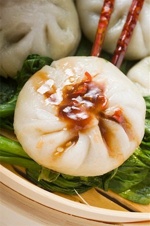 Filled yeast dumplings with Hoisin sauce on pak choi (Thailand) Stock Photo - Premium Royalty-Free, Code: 659-01847838