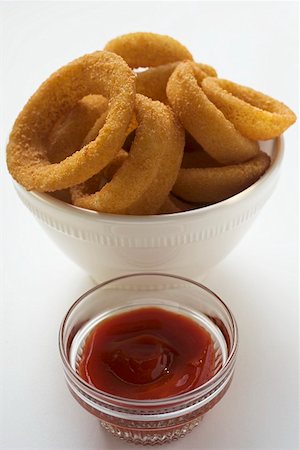 Deep-fried onion rings in white bowl, ketchup Foto de stock - Sin royalties Premium, Código: 659-01847900