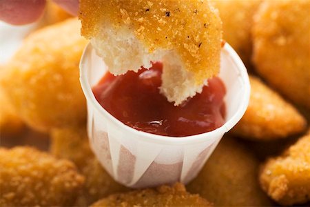 fried chicken - Dipping a chicken nugget in ketchup Stock Photo - Premium Royalty-Free, Code: 659-01847942