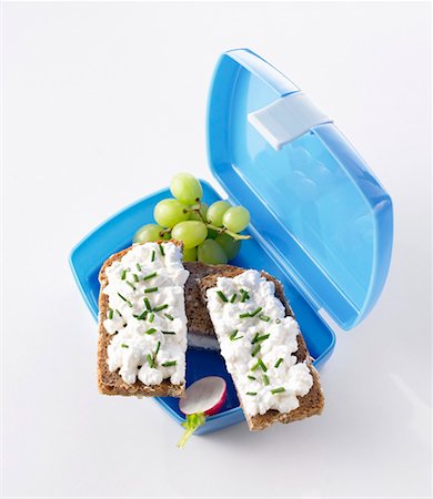 Boîte à lunch avec les sandwiches de fromage à pâte molle, les raisins et les radis Photographie de stock - Premium Libres de Droits, Code: 659-01848325