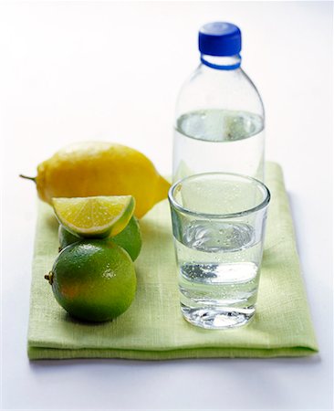 simsearch:659-01855169,k - Eau minérale en bouteille et le verre à côté de citrons et citrons verts Photographie de stock - Premium Libres de Droits, Code: 659-01848362