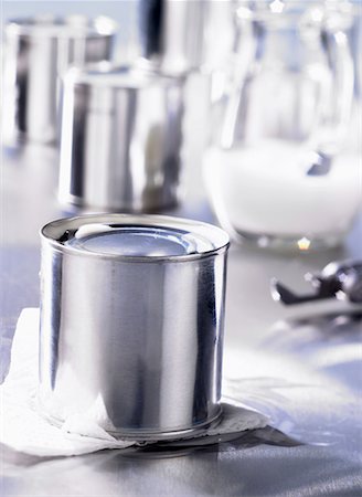 Tinned milk, milk jug in background Stock Photo - Premium Royalty-Free, Code: 659-01849004