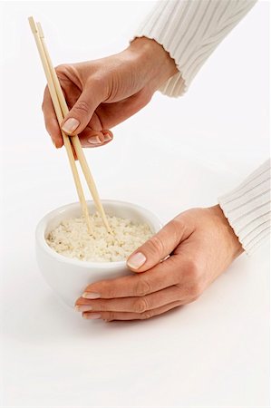 simsearch:659-08419252,k - Woman’s hands holding chopsticks in a bowl of rice (2) Fotografie stock - Premium Royalty-Free, Codice: 659-01849069