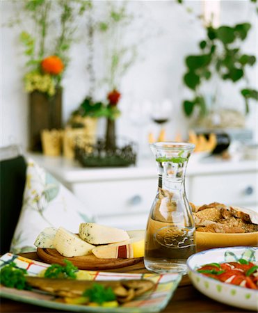 Cheese, fish, bread and tomato salad on a table Fotografie stock - Premium Royalty-Free, Codice: 659-01849122