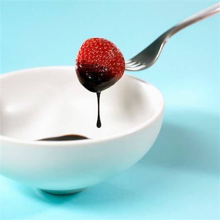 A strawberry being dipped in chocolate Stock Photo - Premium Royalty-Free, Code: 659-01849202