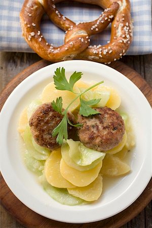 simsearch:659-03535190,k - Burgers on potato and cucumber salad with pretzel Foto de stock - Royalty Free Premium, Número: 659-01849826