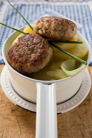 Burgers on potato and cucumber salad Stock Photo - Premium Royalty-Free, Code: 659-01849823