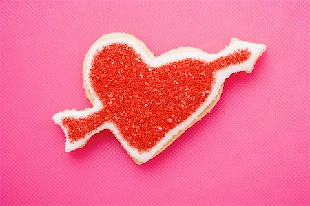Heart-shaped biscuit with arrow, decorated with red sugar Stock Photo - Premium Royalty-Free, Code: 659-01849924